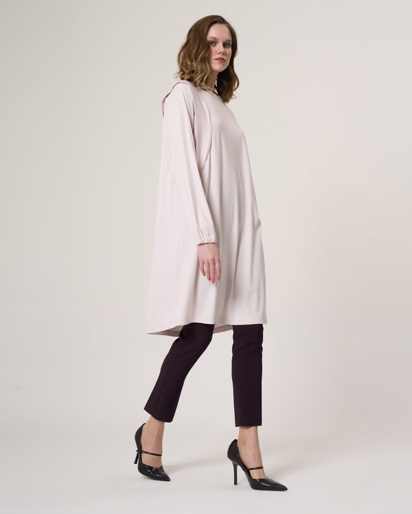35025 beige longline tunic with curved seam detailing, styled with dark trousers