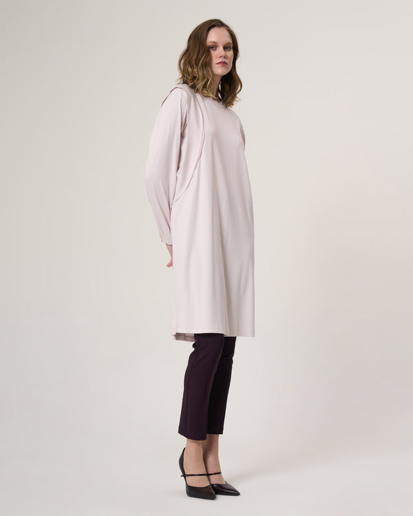 Three-quarter view of the 35025 beige longline tunic showing the curved shoulder seam detail and long gathered sleeves